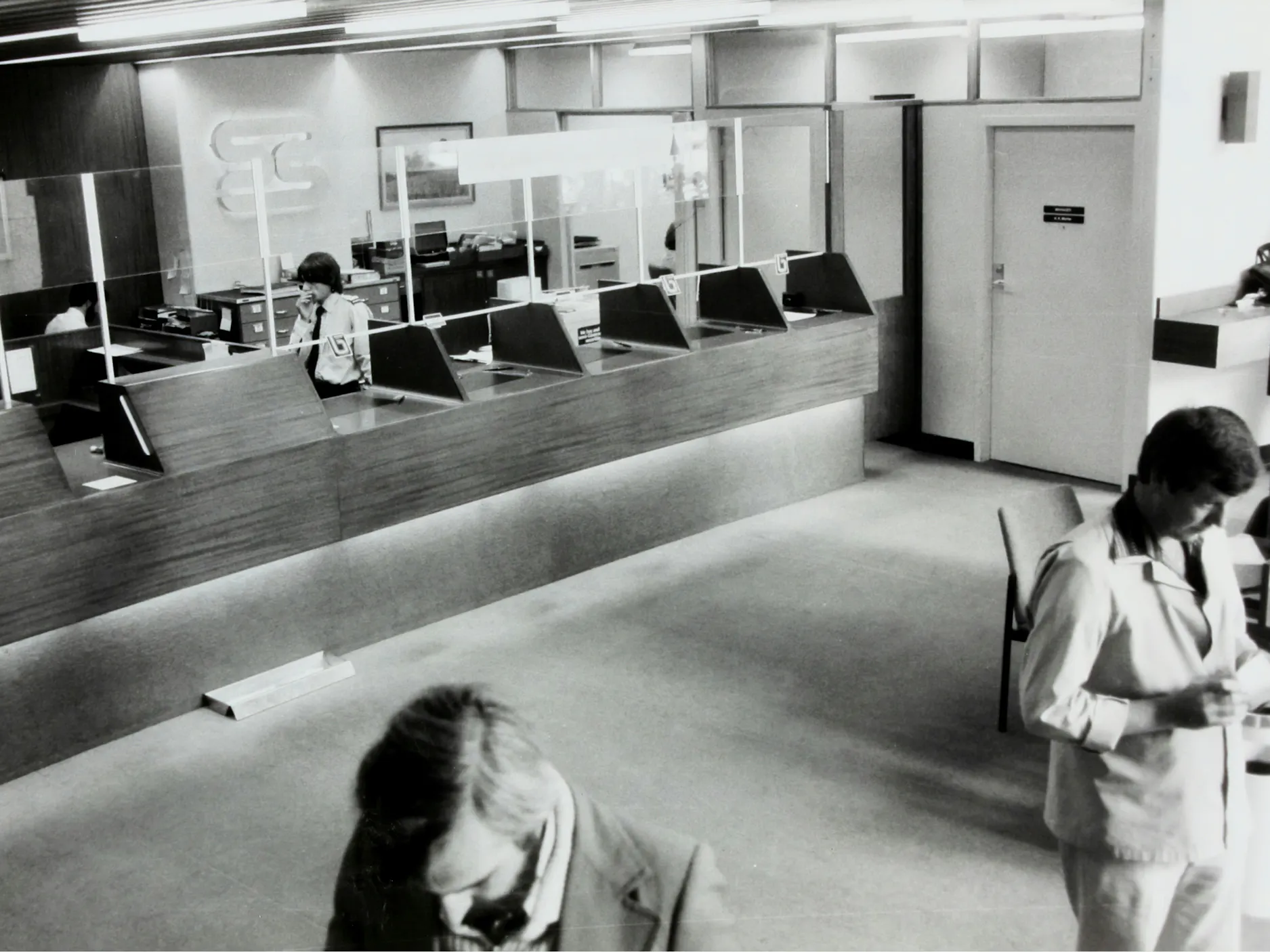 Črno-bela fotografija čakalnice pred okenci